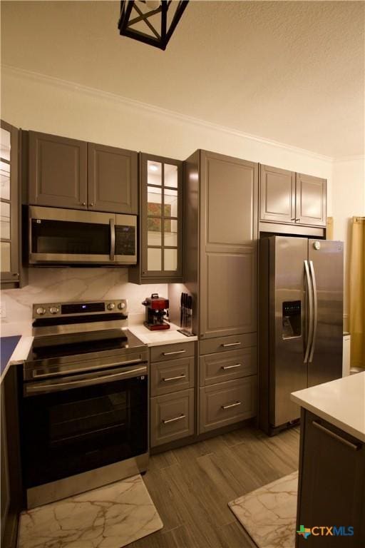 kitchen featuring crown molding, appliances with stainless steel finishes, and wood-type flooring