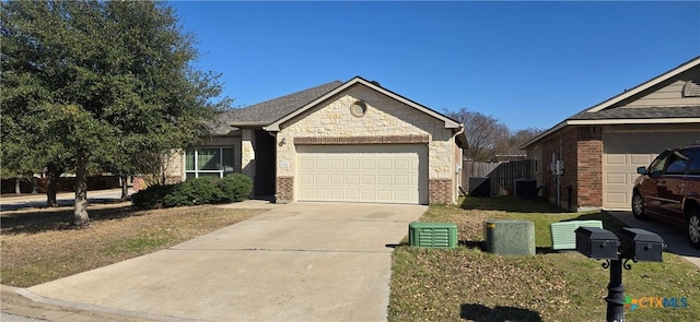 view of front facade with brick siding, concrete driveway, central AC unit, a garage, and stone siding