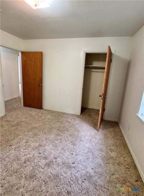 unfurnished bedroom featuring carpet flooring and a closet