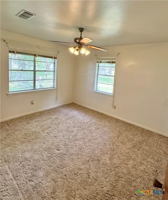 carpeted empty room featuring a ceiling fan, baseboards, and a textured ceiling