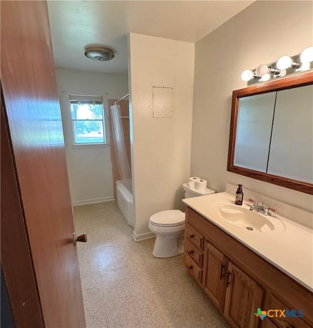 full bath featuring vanity, toilet, shower / bath combo with shower curtain, and baseboards