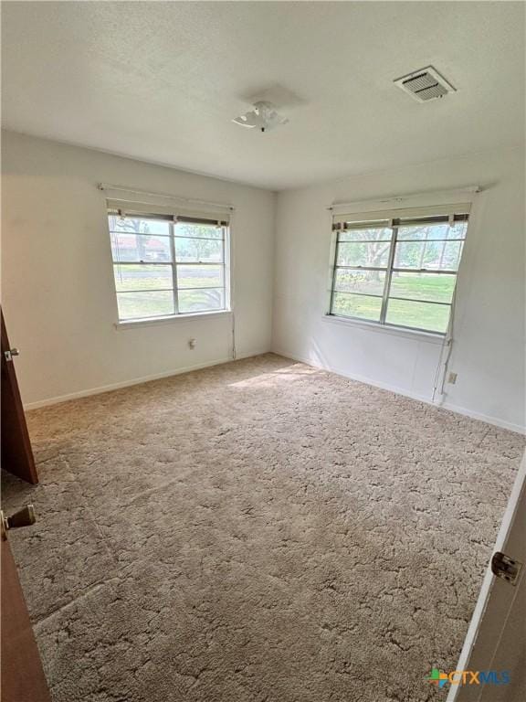 spare room featuring carpet and baseboards