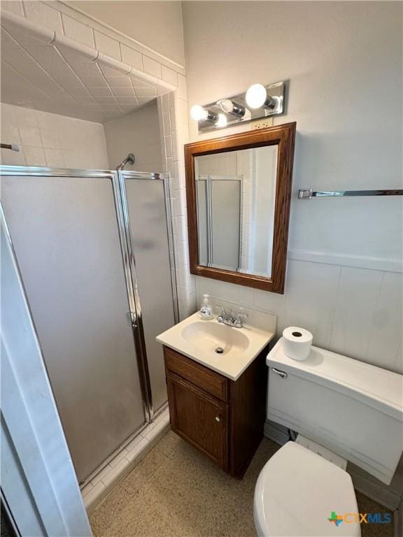 bathroom featuring a shower stall, vanity, and toilet