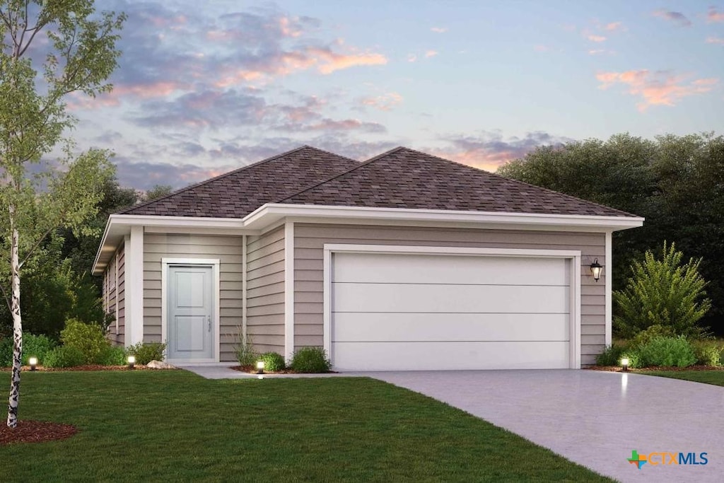 view of front of property with a garage and a yard