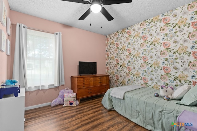 bedroom with multiple windows, a textured ceiling, dark wood-type flooring, and ceiling fan