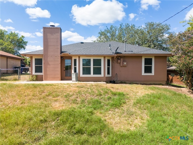 rear view of property featuring a lawn