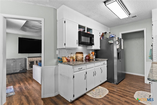 kitchen with white cabinetry, dark stone countertops, dark hardwood / wood-style flooring, and black appliances