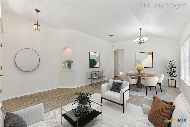 8430 Alvin High Ln, Austin, TX 78729 - living area with a chandelier, light wood finished floors, vaulted ceiling, and baseboards