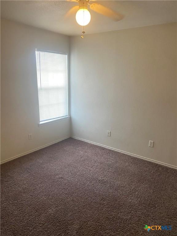 carpeted empty room featuring ceiling fan