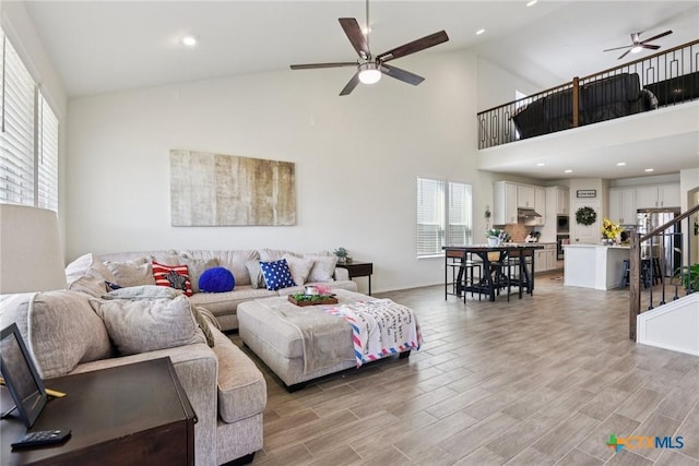 4032 Wild Bloom Rd, Seguin, TX 78155 - living area featuring a ceiling fan, high vaulted ceiling, stairway, light wood finished floors, and recessed lighting
