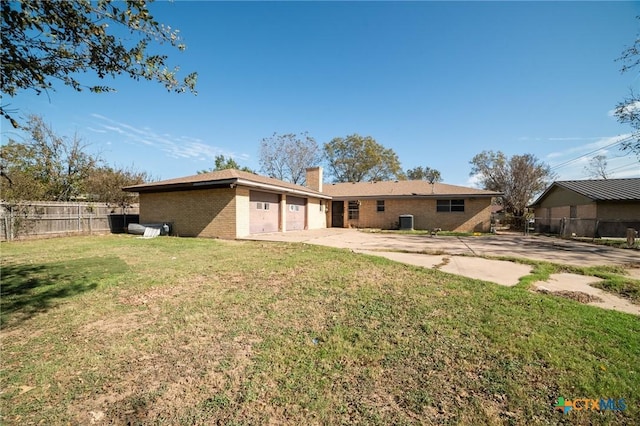 back of house with a yard and central AC