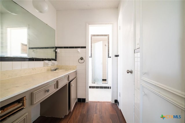 bathroom featuring hardwood / wood-style flooring, vanity, and tile walls