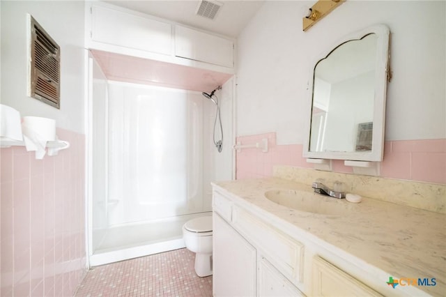 full bathroom with vanity, shower / tub combination, tile walls, tile patterned flooring, and toilet