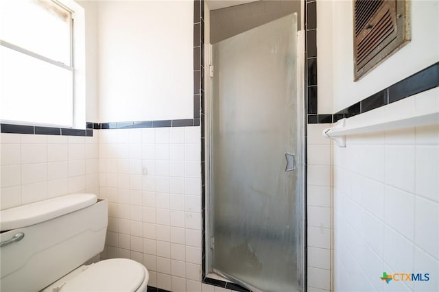 bathroom featuring toilet, tile walls, and walk in shower