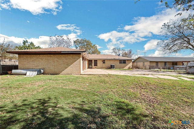 back of property with a patio area and a yard