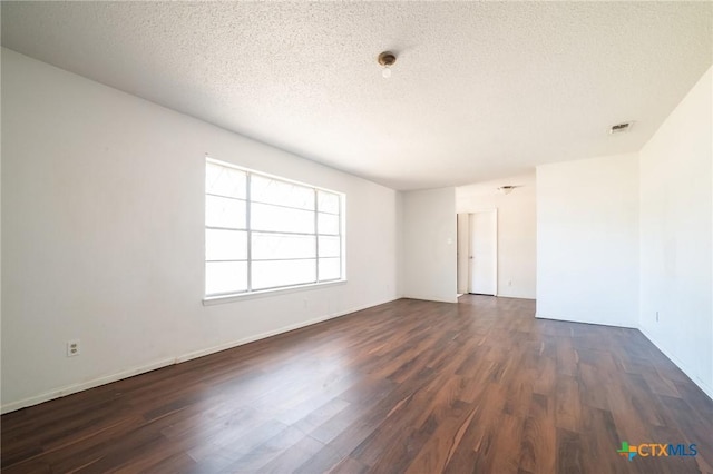 unfurnished room with a textured ceiling and dark wood-type flooring