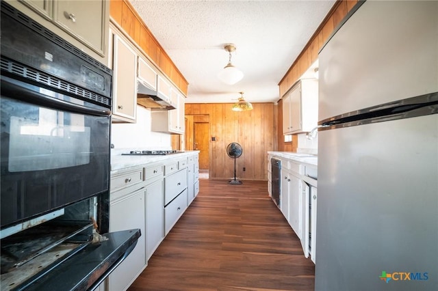 kitchen featuring pendant lighting, dark hardwood / wood-style floors, white cabinetry, and black appliances