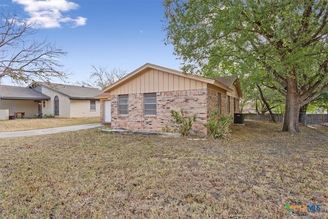 ranch-style home with a front yard and cooling unit