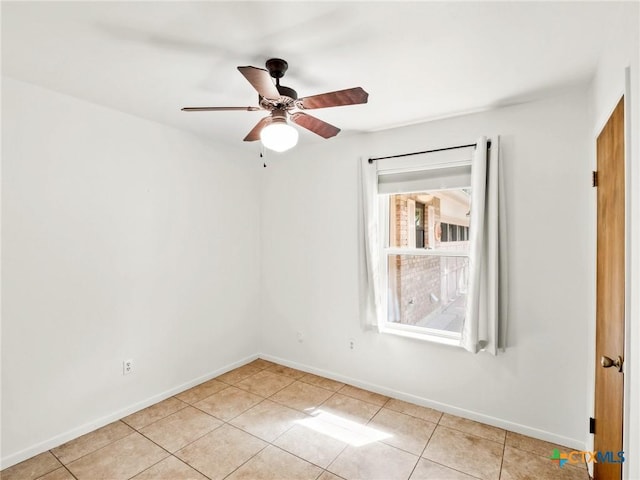 spare room with light tile patterned floors, baseboards, and ceiling fan