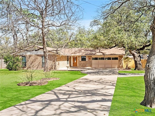 ranch-style house with fence, a front lawn, concrete driveway, a garage, and brick siding