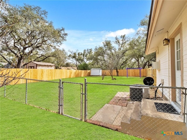 view of yard with a gate, a fenced backyard, and central AC