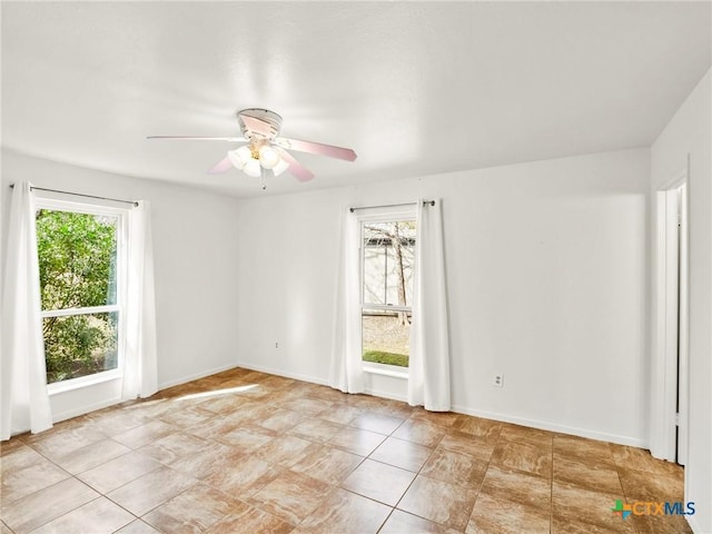 empty room featuring baseboards and a ceiling fan