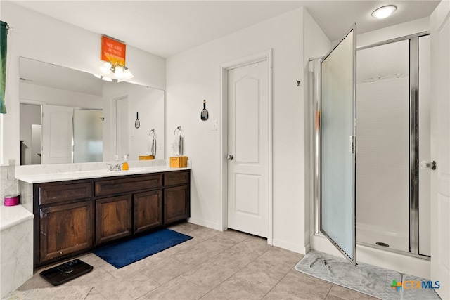 full bath with baseboards, a shower stall, vanity, and tile patterned floors