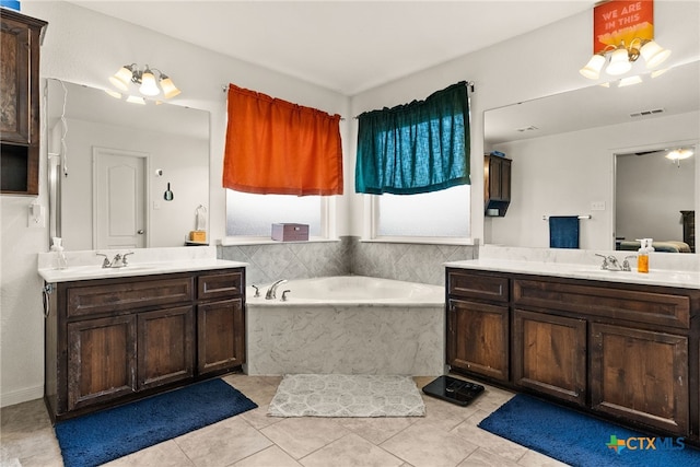 full bath with a sink, a garden tub, visible vents, and two vanities