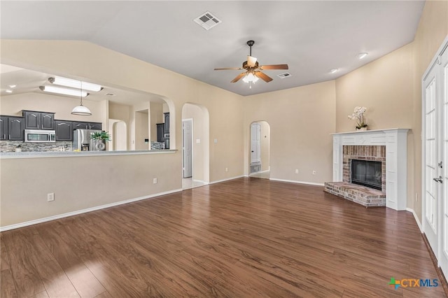 2003 Schottische Ln, Killeen, TX 76542 - unfurnished living room with ceiling fan, dark wood-type flooring, lofted ceiling, arched walkways, and a fireplace