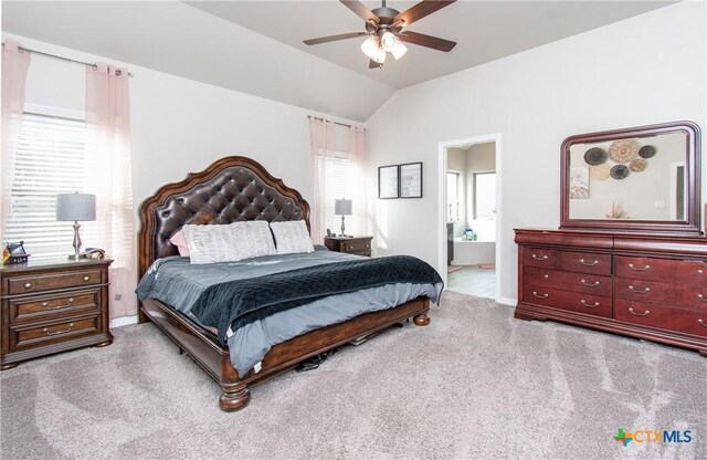 carpeted bedroom with ceiling fan, connected bathroom, and vaulted ceiling