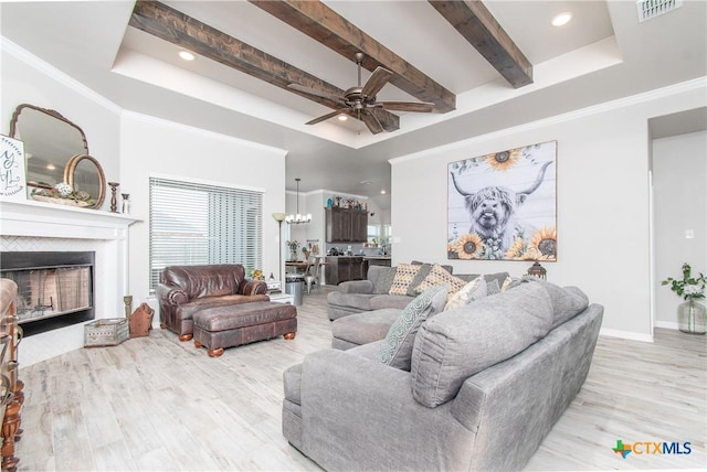 living room with ornamental molding, ceiling fan, light hardwood / wood-style flooring, and a tray ceiling