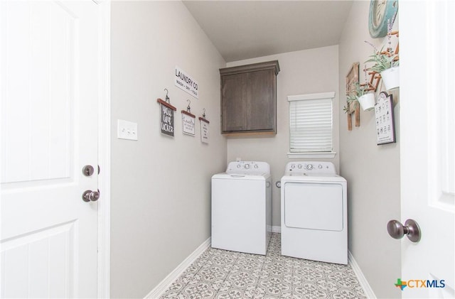 laundry room with washer and dryer, light tile patterned floors, and cabinets