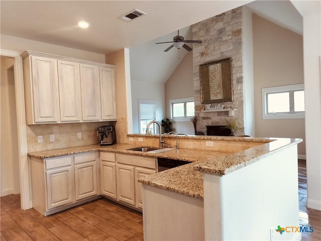 127 Augusta Dr, Wimberley, TX 78676 - kitchen featuring a sink, a ceiling fan, a fireplace, a peninsula, and light wood finished floors