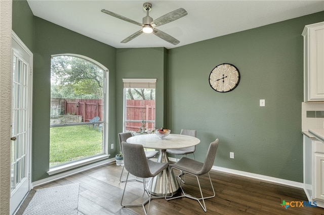 dining area featuring wood finished floors, baseboards, and ceiling fan