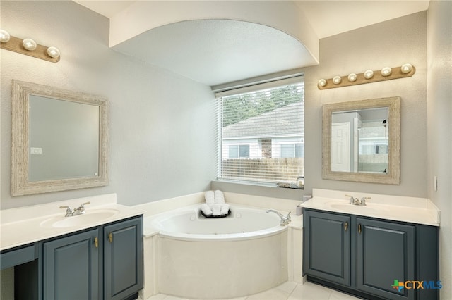 full bathroom with a sink, two vanities, a whirlpool tub, and tile patterned floors