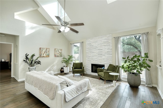 living area featuring plenty of natural light, a fireplace, high vaulted ceiling, and wood finished floors