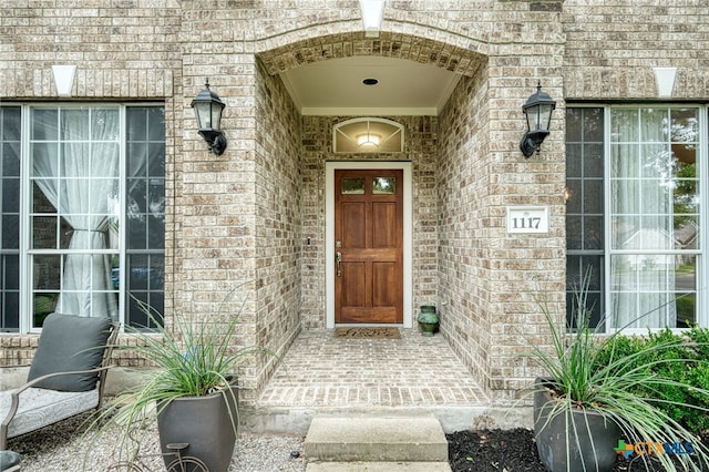 doorway to property with brick siding