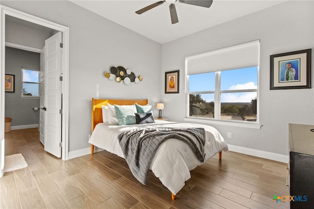 bedroom featuring multiple windows, ceiling fan, and light wood-type flooring