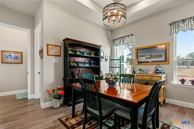 dining space with hardwood / wood-style floors and an inviting chandelier