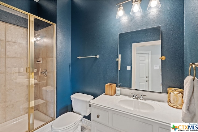 bathroom with toilet, a shower stall, vanity, and a textured wall