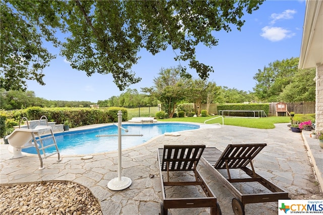 view of swimming pool featuring a fenced in pool, a patio area, a yard, and a fenced backyard