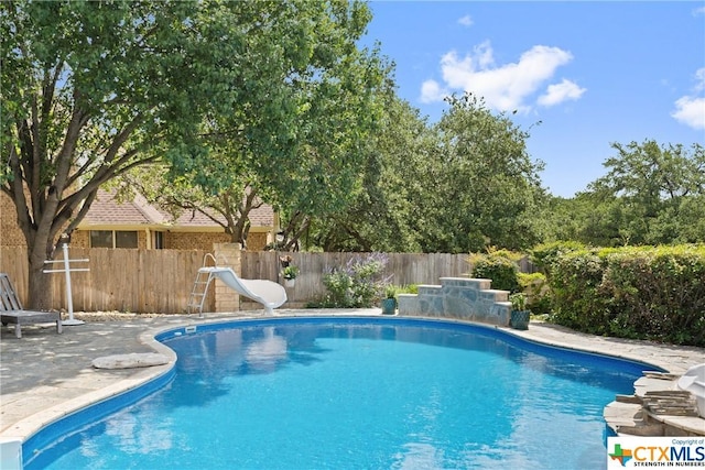 445 Champions Dr, Georgetown, TX 78628 - view of pool featuring a water slide, a fenced backyard, and a patio