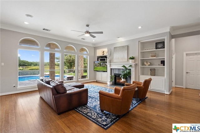 445 Champions Dr, Georgetown, TX 78628 - living room featuring a ceiling fan, crown molding, a premium fireplace, hardwood / wood-style flooring, and baseboards