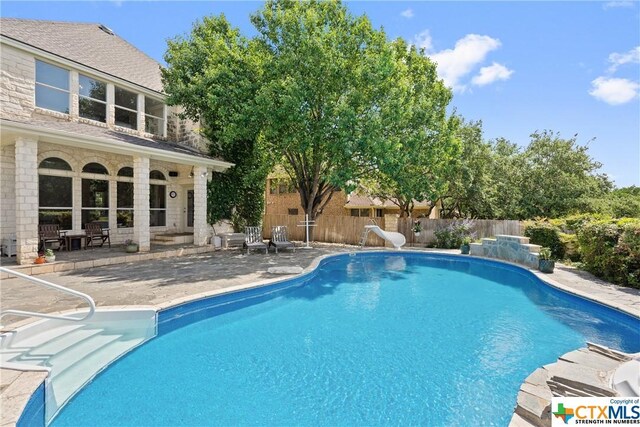 445 Champions Dr, Georgetown, TX 78628 - view of swimming pool featuring a patio, fence, and a water slide