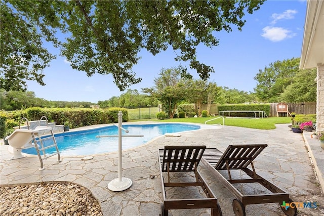 view of swimming pool featuring a fenced backyard, a lawn, a fenced in pool, and a patio