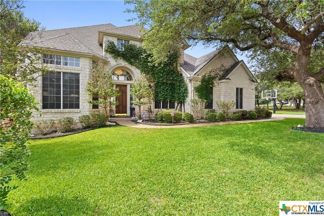 445 Champions Dr, Georgetown, TX 78628 - view of front facade with a front yard, stone siding, and a shingled roof