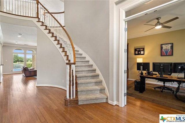 445 Champions Dr, Georgetown, TX 78628 - staircase with crown molding, wood finished floors, ceiling fan, and baseboards