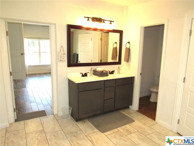 bathroom featuring wood-type flooring, toilet, and vanity