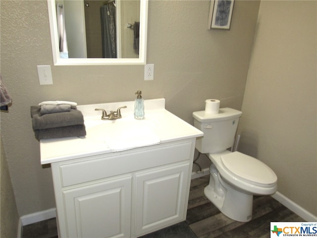 bathroom featuring hardwood / wood-style floors, vanity, and toilet