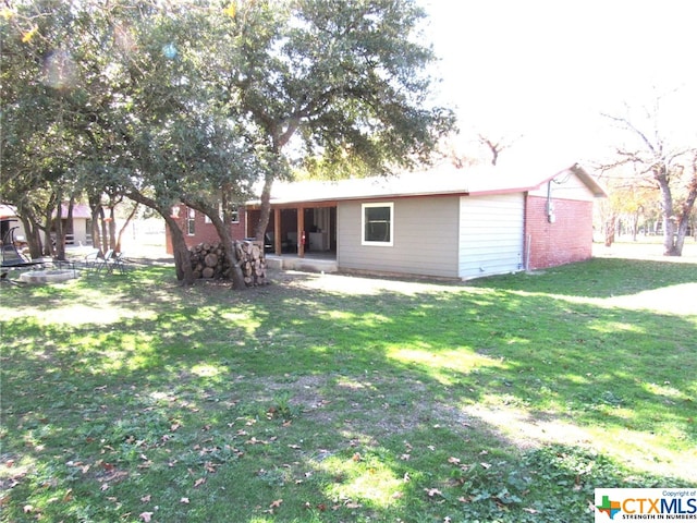 back of property featuring a patio and a yard